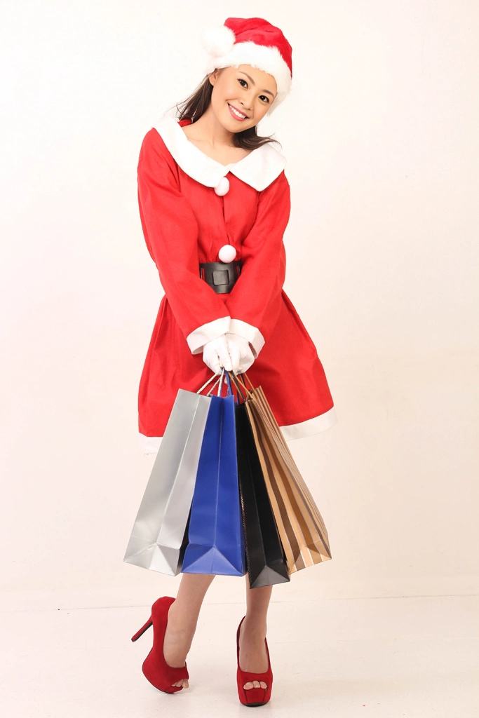 Portrait of an Asian Woman in Santa Costume Holding Shopping Bags and Tilting Her Head #1, Photo