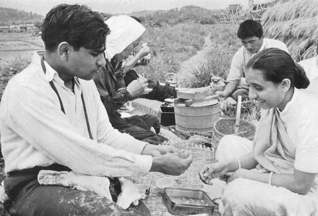 「ある印度人夫妻 （研修先の農家の人たちと昼食をとるインド人夫妻）」 佐藤英雄&nbsp;-&nbsp;アサヒカメラ 1956年7月号より
